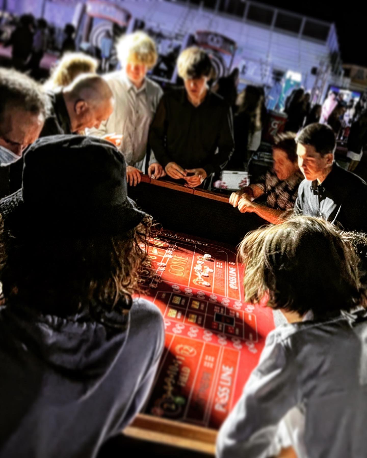 Guests crowded around a glowing craps table at a CPD-staffed outdoor casino night